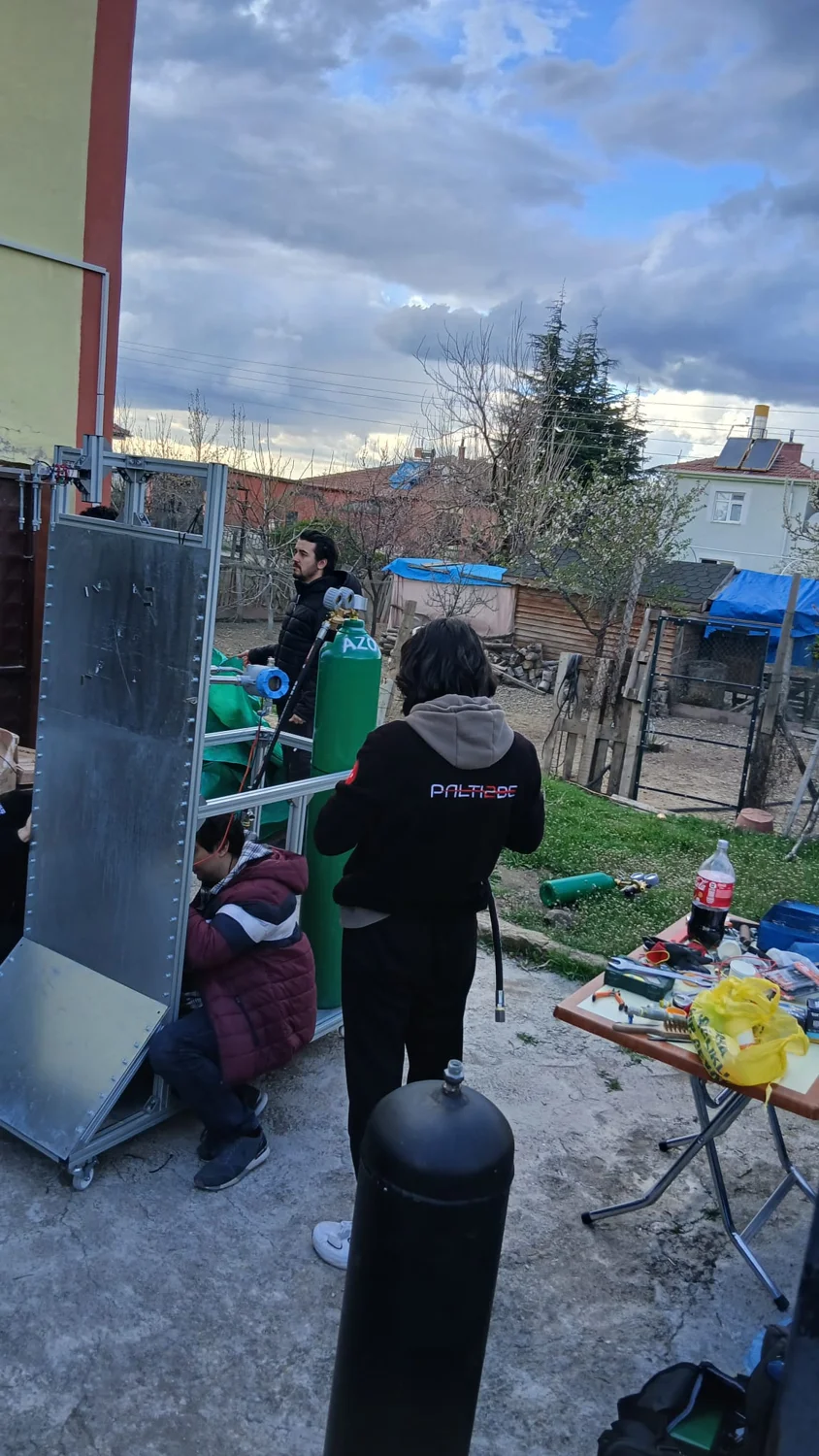 Köy evinin bahçesinde test altyapısı üzerinde çalışan takım üyeleri